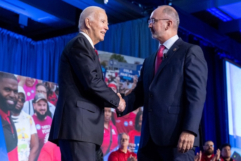 President Joe Biden (l.), who has spoken out in support of the Volkswagen unionization push, shakes hands with United Auto Workers President Shawn Fain.