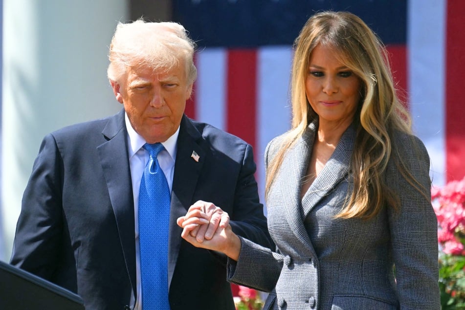 President Donald Trump (l.) holds hands with First Lady Melania Trump during a bill signing ceremony in the Rose Garden of the White House in Washington DC on May 19, 2025.