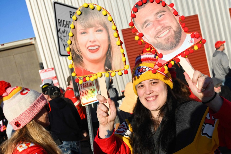 A fan held up signs of Taylor Swift and Travis Kelce during the Kansas City Chiefs Super Bowl LVIII victory parade on Wednesday in Kansas City, Missouri.