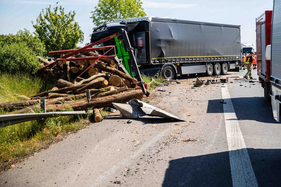 Im Hintergrund ist der Lkw zu sehen, der dem Laster vor ihm auffuhr. Dessen Holzladung, die im Vordergrund zu sehen ist, verlor der Vorausfahrende bei dem Unfall.