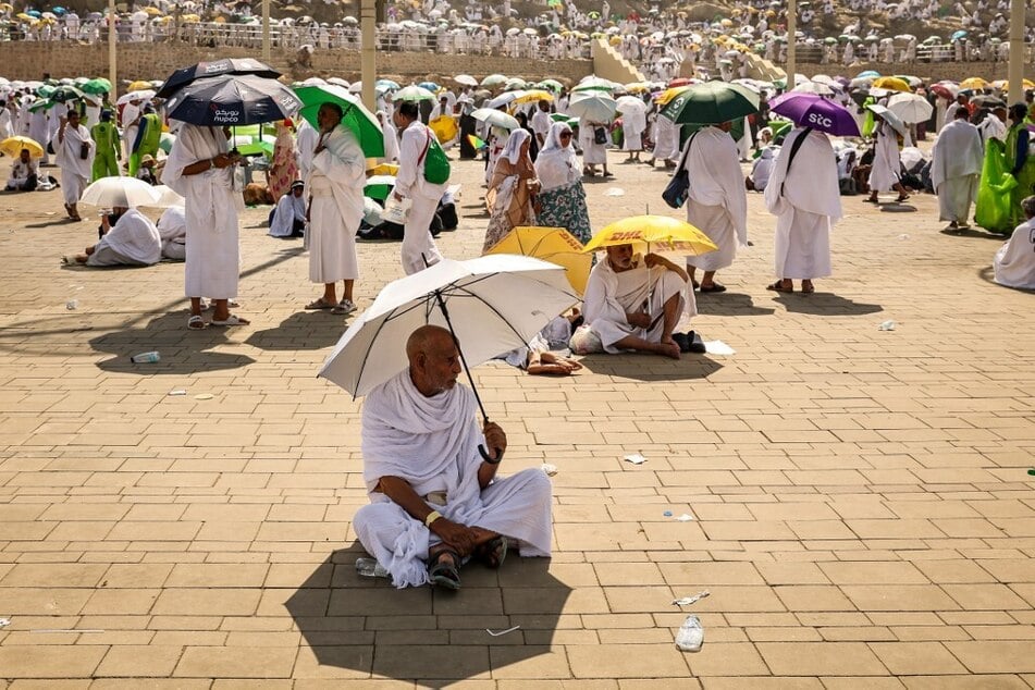 Muslim pilgrims use umbrellas to shade themselves from the sun as they arrive at the base of Mount Arafat, also known as Jabal al-Rahma or Mount of Mercy, during the annual hajj pilgrimage on June 15, 2024.