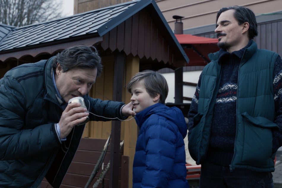 Henri Schütz (Harald Windisch, 59, l.), spielt mit seinem Sohn Emil Schütz (Morris Mayer, 10, M.), als Eric Weber (Hannes Wegener, 44, r.) dazukommt.