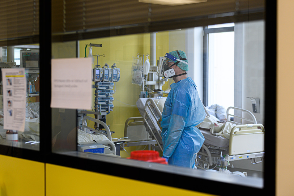 Ein Intensivpfleger ist auf der Covid-19-Intensivstation im Städtischen Klinikum Dresden mit der Versorgung von Corona-Patienten beschäftigt. Am Mittwoch wurde eine gestiegen Anzahl von Infizierten gemeldet.
