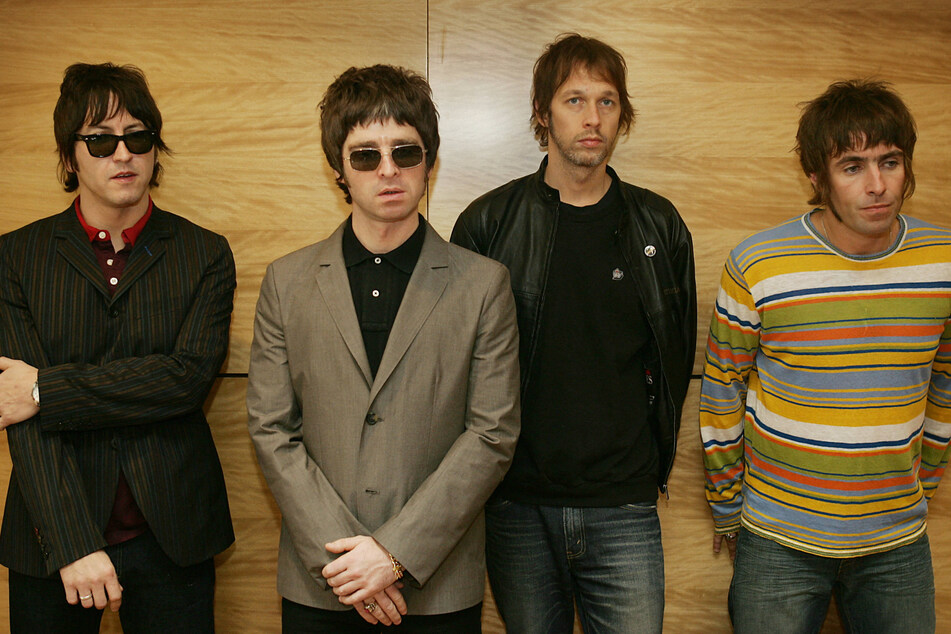 Fans of British rock band Oasis buzzed with anticipation Monday as Liam (r.) and Noel Gallagher (center l.) teased that they could be returning to the stage together, 15 years after the band's last performance.