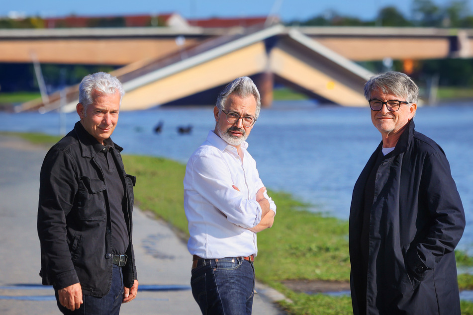 Herausgeber Peter Ufer (59), Amac Garbe (45) und Thomas Walther (64, v.l.) vor einem dann doch aktuellen Fotomotiv - der eingestürzten Carolabrücke.