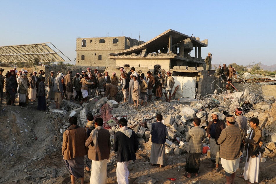 People gather at the site of a house hit by a US strike in Saada, Yemen, on March 16, 2025.