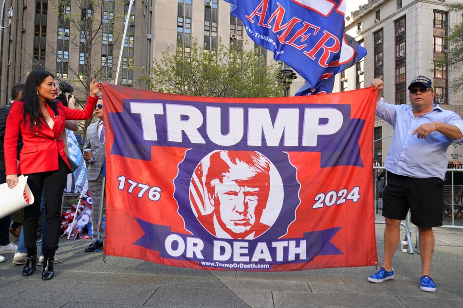 Donald Trump supporters holding a flag that reads "Trump or death".