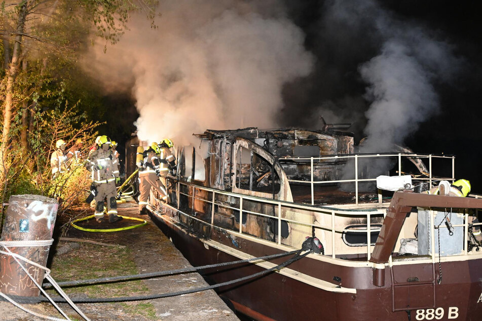 Alarmierte Feuerwehrleute bekämpften das Feuer auf einem angelegten Boot.