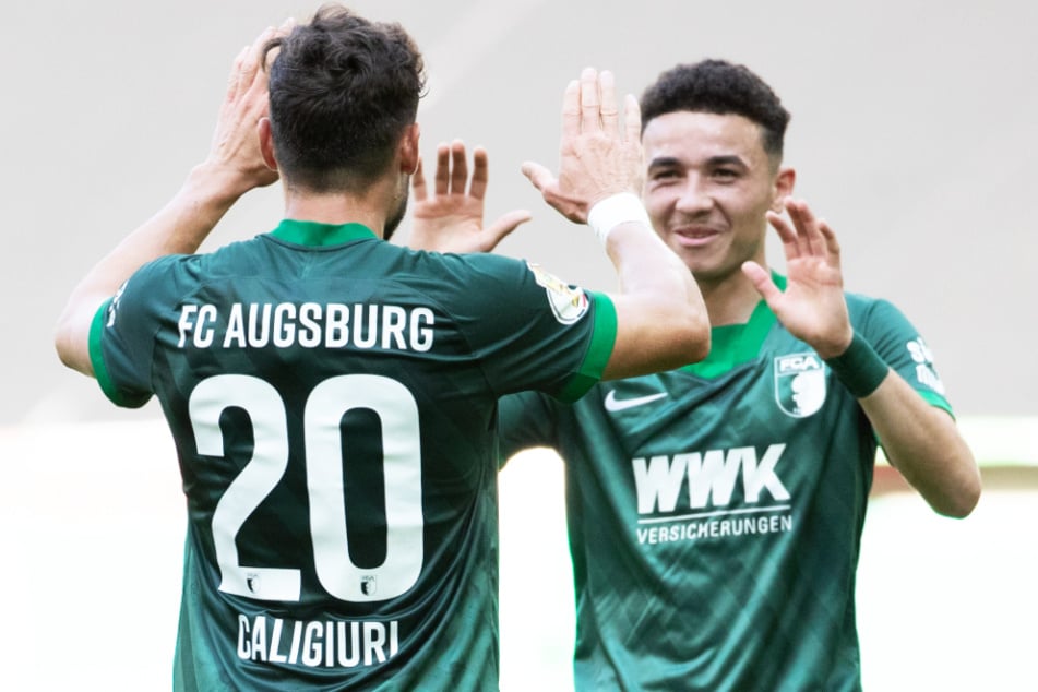 Daniel Caligiuri (l.) und Ruben Vargas haben gute Chancen, den vorzeitigen Klassenerhalt mit dem FC Augsburg zu feiern.