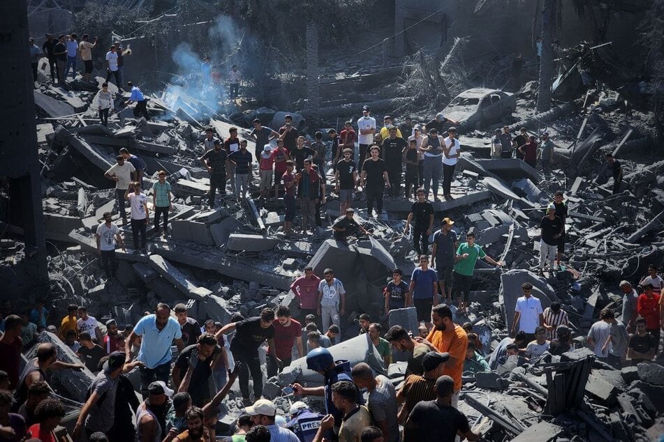 Einwohner des Gaza-Streifens kommen nach einem Luftangriff zusammen um nach Opfern zu suchen.