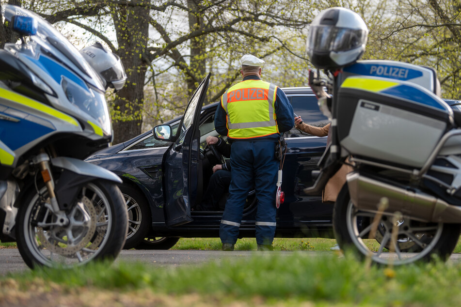 Ein Polizist der Leipziger Verkehrspolizei kontrolliert einen Autofahrer an der Jahnallee in Leipzig.