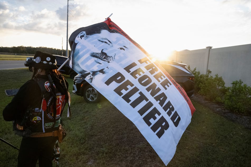 Gina Marie Rangel Quinones raises a flag outside the Coleman Federal Correctional Complex as Leonard Peltier is released from prison.