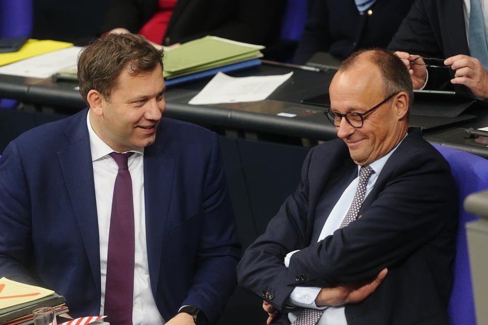 Lars Klingbeil (47, SPD, l.), Bundesminister der Finanzen, spricht mit Bundeskanzler Friedrich Merz (CDU) während der Sitzung des Bundestags.