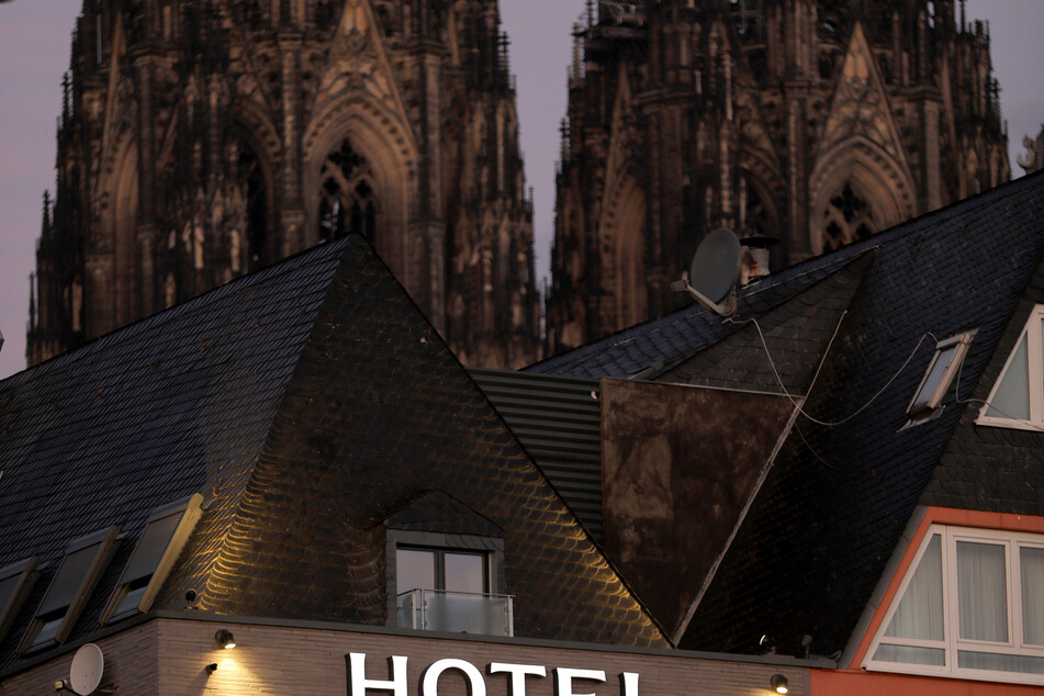 Ein Schriftzug leuchtet an einem Hotel in der Nähe des Domes. (Symbolbild)