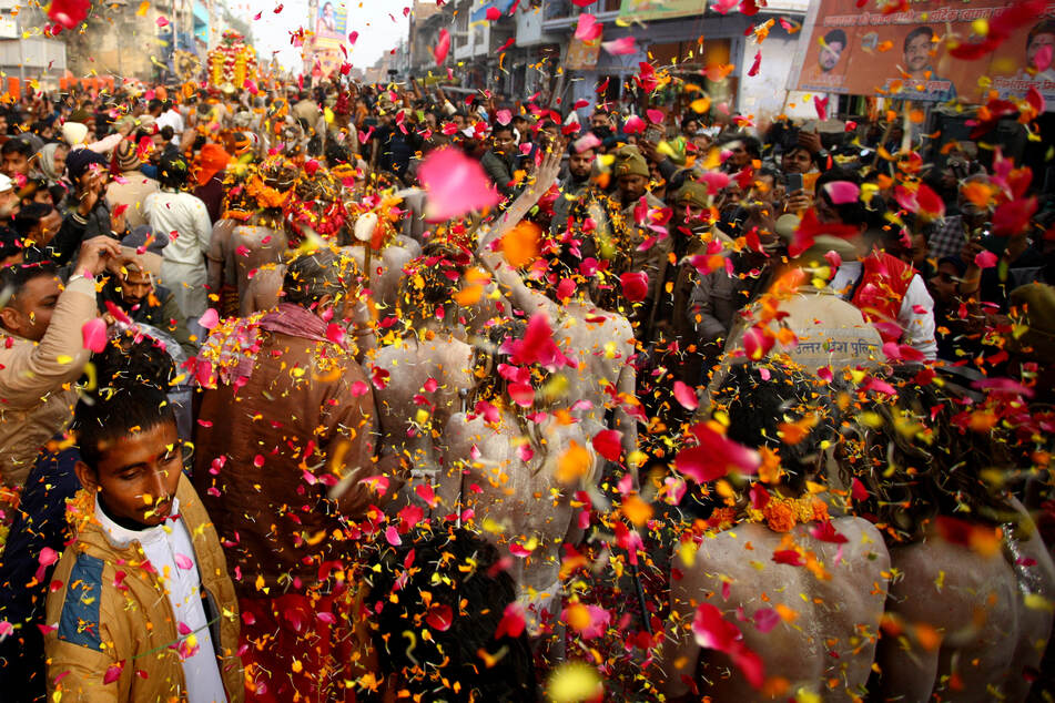 Naga Sadhus or Hindu holy men from Niranjani Akhara are showered with flower petals as they take part in a religious procession during Peshwai, or the arrival of the members of an akhara or sect of sadhus for the upcoming Maha Kumbh Mela in Prayagraj, India.