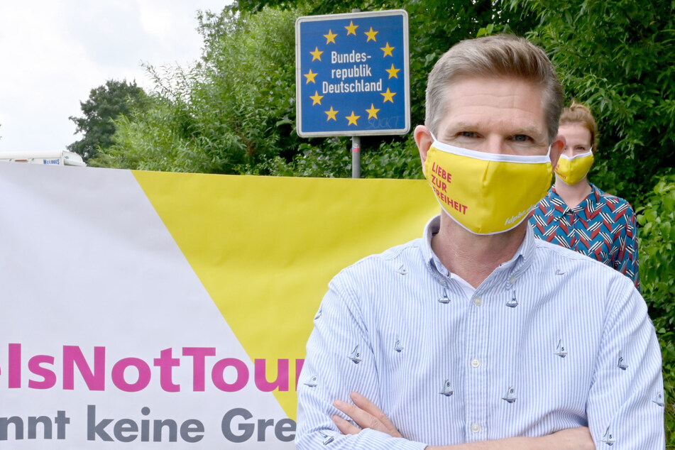 Mit einer Schutzmaske steht Heiner Garg (54), FDP-Landesvorsitzender und Gesundheitsminister von Schleswig-Holstein, bei einer Demonstration am Grenzübergang Padborg.