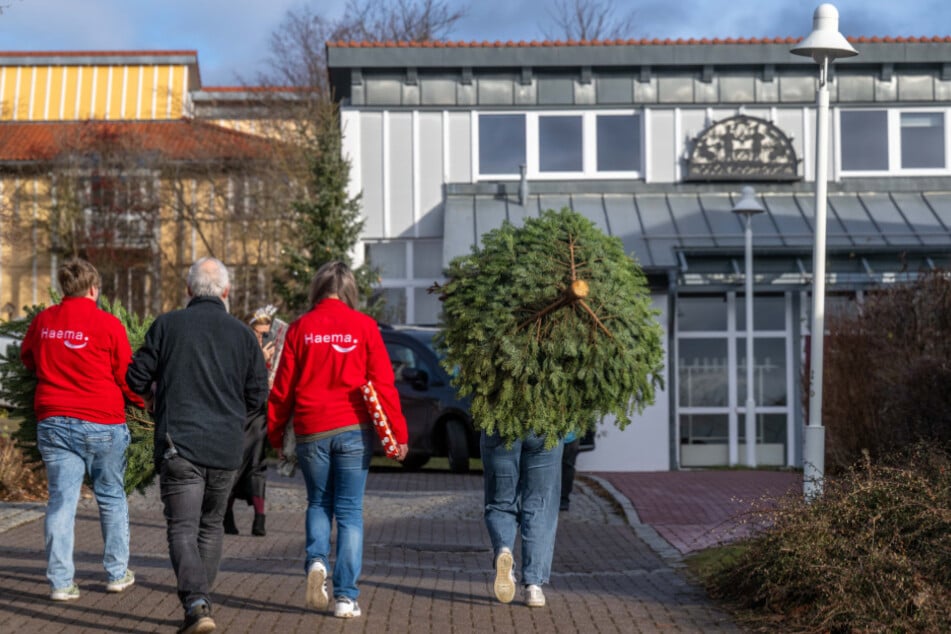 Mit einem großen Weihnachtsbaum und Geschenken im Gepäck machen sich Helfer auf den Weg ins SOS-Kinderdorf Zwickau.