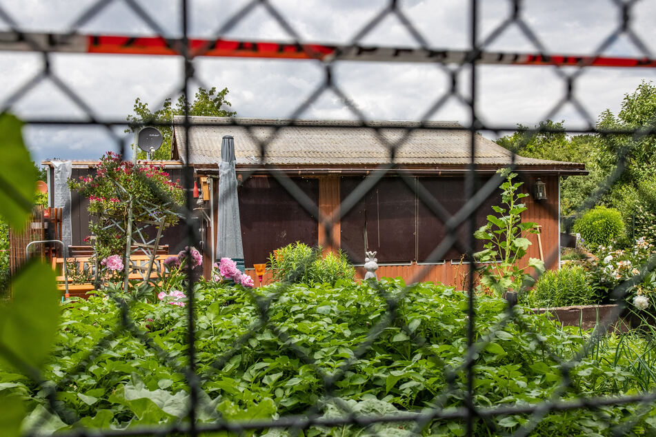Absperrband umgibt das Grundstück in einer Kleingartenkolonie am Stadtrand von Münster mit einer Gartenlaube, von der man hier die Rückseite sieht. Die Laube ist einer der Tatorte des vermutlichen Haupttäters in einem Missbrauchsfall, in der die Ermittler u.a. Festplatten und Videokameras fanden.