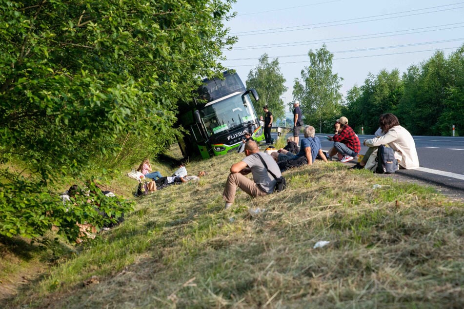 Nach dem Busunglück warten viele Menschen auf die Weiterfahrt.