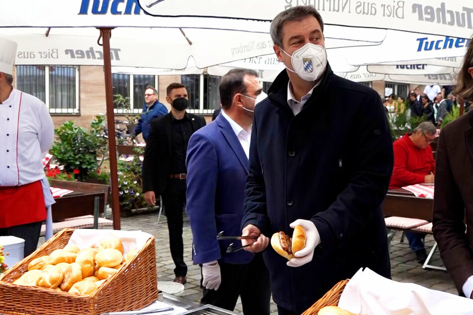 CSU-Chef Markus Söder (54) verteilt an Impfwillige zur Stärkung nach der Spritze "Drei im Weggla".