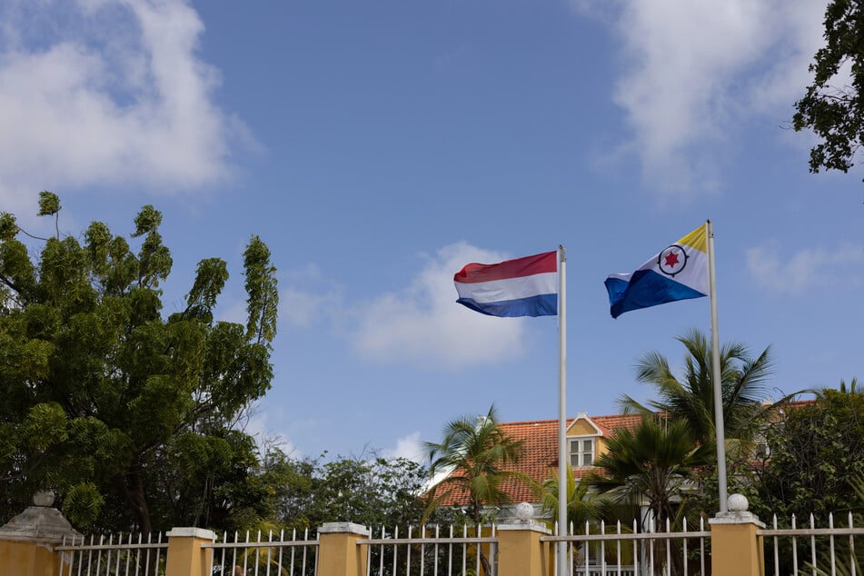 The flag of the Netherlands flies next to that of Bonaire in front of a house.