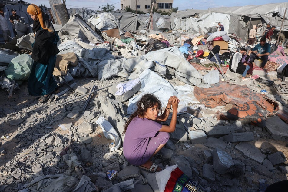 A girl looks on as Palestinians assess damage at the site of an Israeli airstrike in Khan Younis, in the southern Gaza Strip, on June 7, 2026.