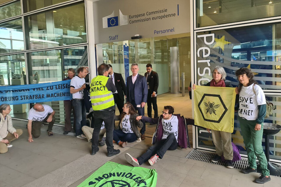 Mehrere Aktivisten klebten sich am Eingang der EU-Kommission fest.