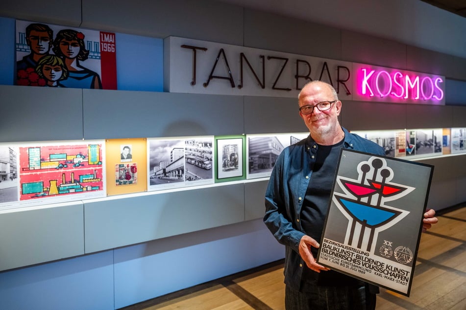 Kurator Peer Ehmke (62) mit einem Plakat des Klapperbrunnens aus Chemnitz.