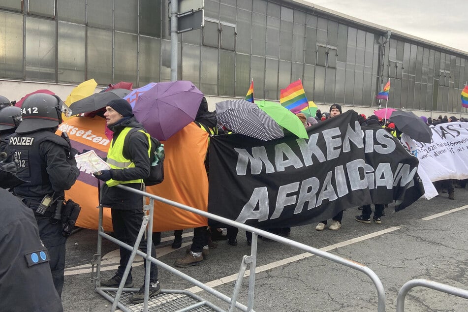 Mehrere Teilnehmer haben Regenbogenfahnen dabei.