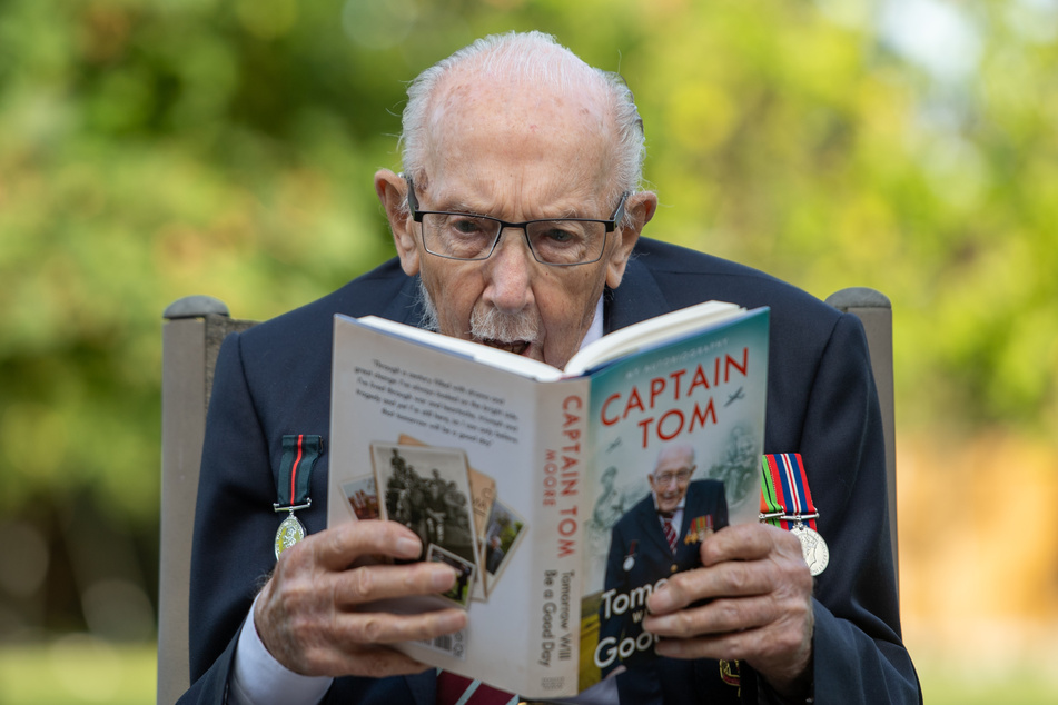 Captain Sir Tom Moore hält in seinem Haus in Marston Moretaine, Bedfordshire, am Tag der Veröffentlichung seiner Autobiographie "Tomorrow Will Be A Good Day" ein Exemplar des Buchs.