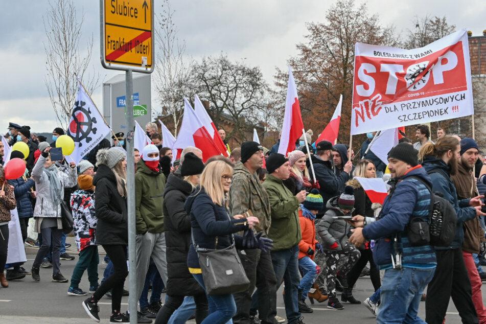 Aus dem polnischen Slubice gehen Teilnehmer einer Demonstration gegen Corona-Maßnahmen über den Grenzübergang Stadtbrücke nach Frankfurt (Oder).