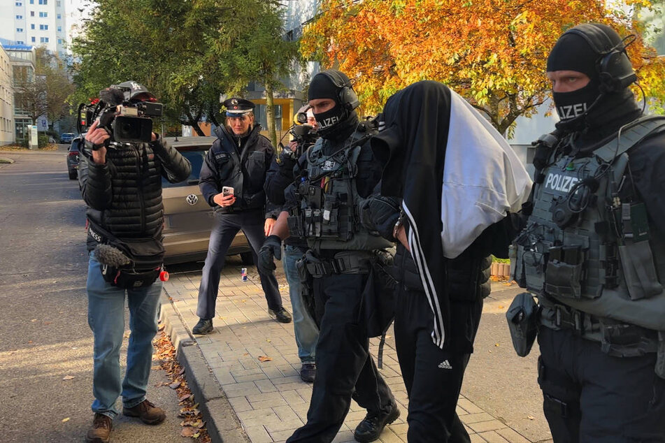 In Berlin wird ein Tatverdächtiger von den Einsatzkräften abgeführt.