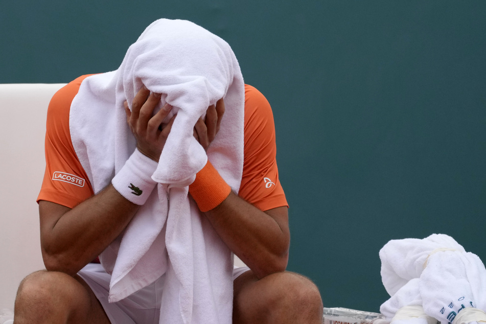 Novak Djokovic (34) hat sein Gesicht im Handtuch vergraben. Der Serbe berichtete nach dem Finale von gesundheitlichen Problemen.