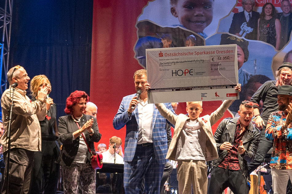 Phil Schaller (15) zeigt zum Finale den Spendenscheck - die Summe wurde nach dem Konzert von einem anonymen Spender aufgerundet.