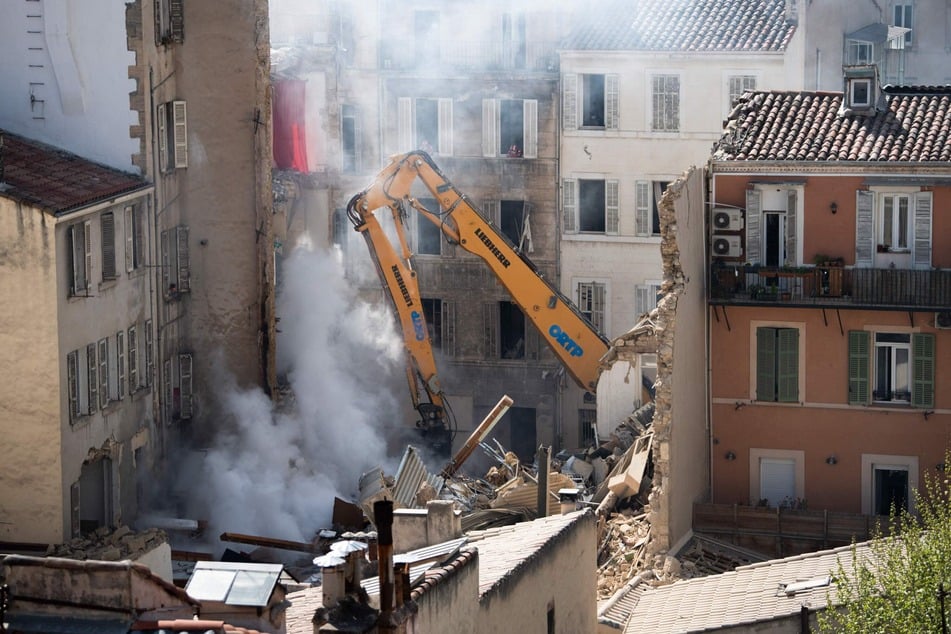 Ein Kran bewegt Schutt des eingestürzten Gebäudes in Marseille. Aufgrund eines Feuers unter den Trümmern sind die Rettungsarbeiten schwierig.