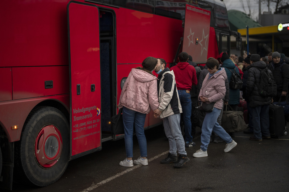 Ein Paar küsst sich zum Abschied, bevor die Frau einen Bus besteigt, der Kiew verlässt.