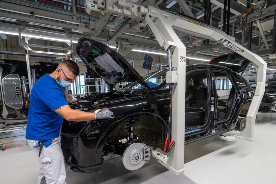 Ein Mitarbeiter im Volkswagen-Werk montiert einen Audi Q4 e-tron.