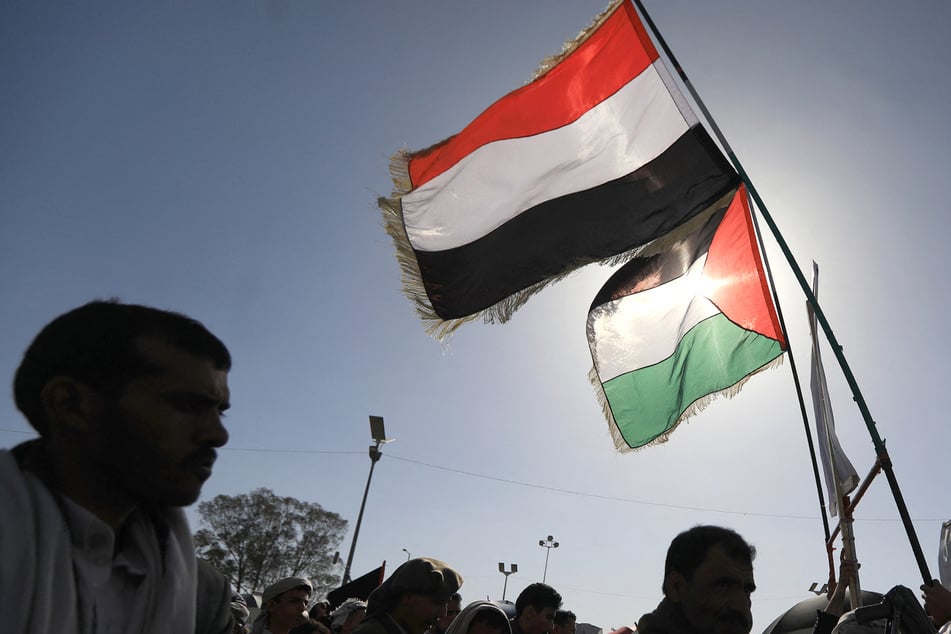 Yemenis holding a Yemeni (top) and Palestinian flag (bottom) march in solidarity with the people of Gaza in the Houthi-run capital Sanaa on June 7.