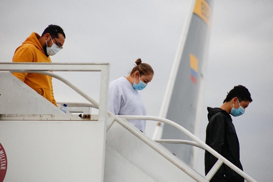 Migrants descend from a Colombian Air Force plane in Bogota after being deported from the US.