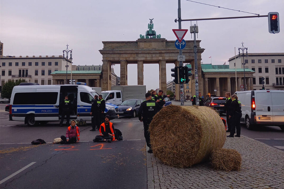 Klimaaktivisten der "Letzten Generation" haben am Donnerstagmorgen gemeinsam mit einigen Landwirten die Fahrbahn am Brandenburger Tor blockiert.
