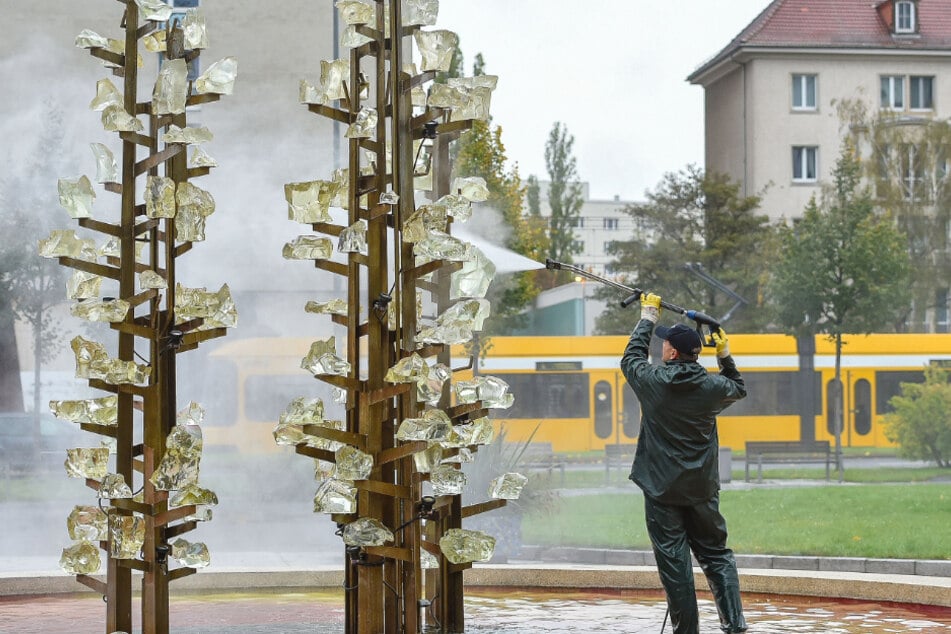 Brunnenbetreuer Uwe Möller (54) reinigt den Glasbrunnen in der Lingnerstadt.