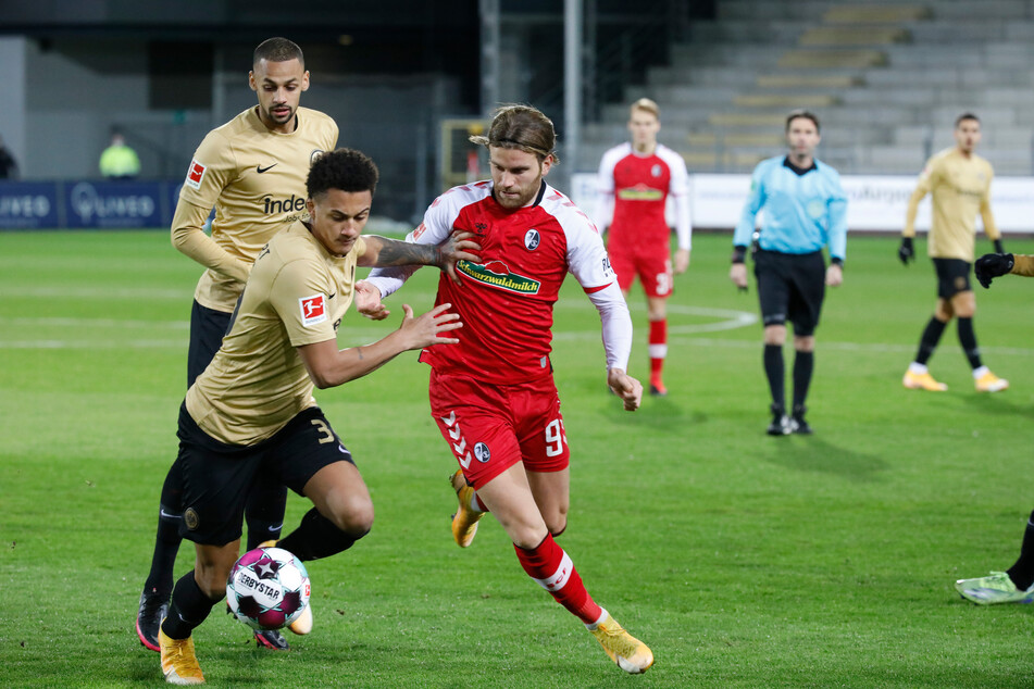Eintracht Frankfurts Djibril Sow (l.) beobachtet Mannschaftskamerad Tuta (v.-l-) im Zweikampf mit Lucas Höler vom SC Freiburg.