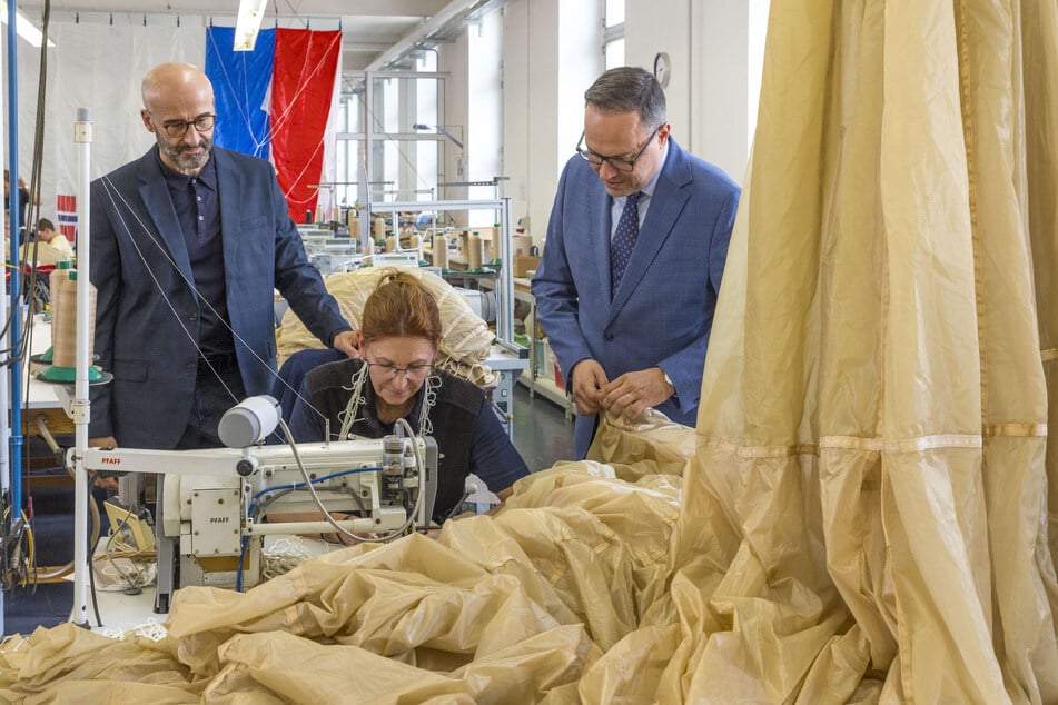 Serdar Kaya (l.) zeigt Wirtschaftsminister Dirk Panter (52, SPD) die Spekon-Fertigung. Dort näht Zdena Kepkova mit der Maschine Fallschirme.