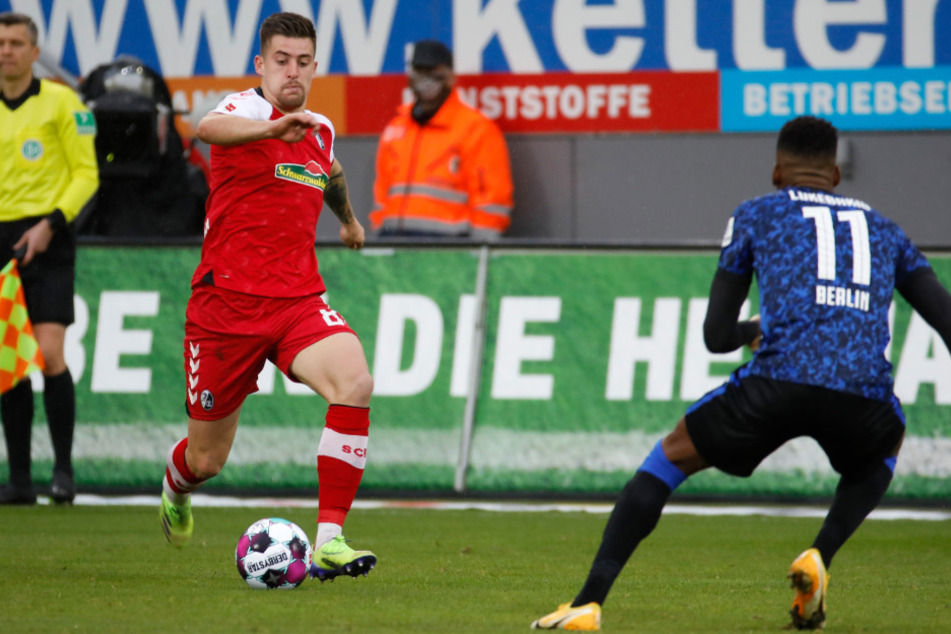 Baptiste Santamaria (l.) vom SC Freiburg im Zweikampf mit Herthas Dodi Lukebakio.