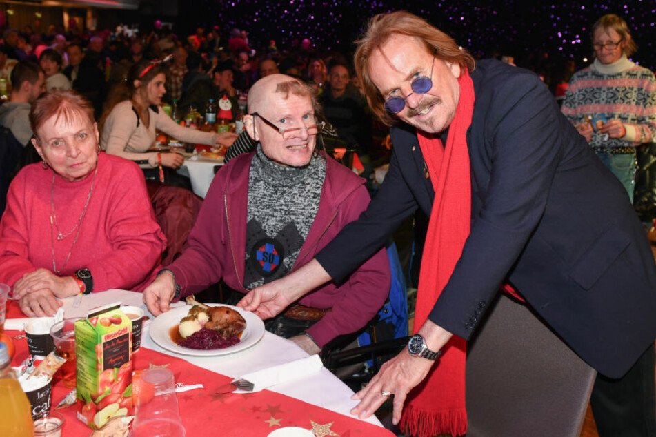 Frank Zander (78, r.) serviert im Jahr 2018 im Hotel Estrel beim traditionellen Weihnachtsessen für Menschen von der Straße Gänsebraten für seine Gäste. 2020 muss er das Fest aufgrund der Corona-Pandemie ausfallen lassen. (Archivfoto)