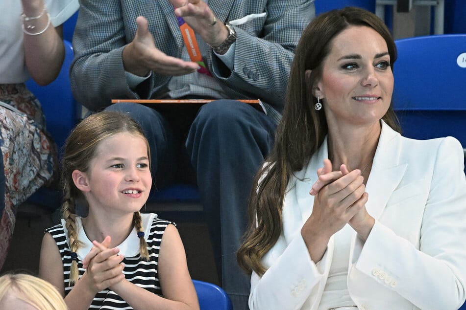 Britain's Princess Charlotte of Cambridge (l.) reacts as she sits with her mother Britain's Catherine, Duchess of Cambridge (r.) to watch the men's 1500m freestyle heats swimming event at the Sandwell Aquatics Centre, on day five of the Commonwealth Games on August 2, 2022.