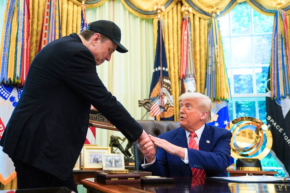 President Donald Trump (r) shakes hands with Elon Musk (l) after gifting him a "key to the White House" during a news conference at the White House on May 30, 2025.