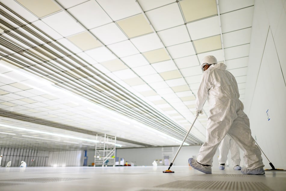 Lupenrein: Reinigungskräfte säubern auf der Baustelle für das neue Infineon-Werk im zukünftigen Reinraum der Smart Power Fab den Boden.