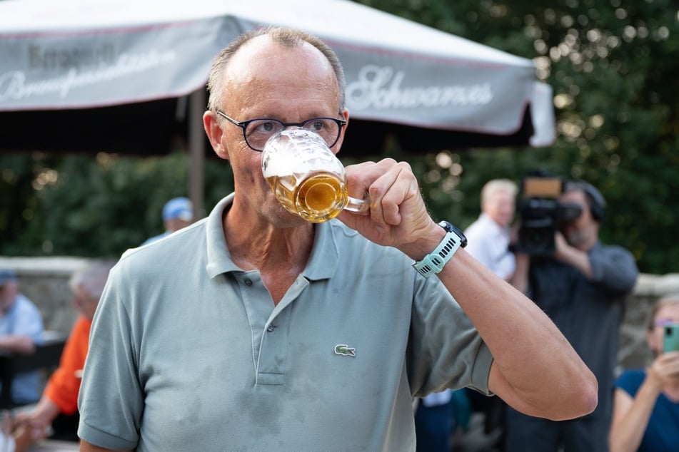 CDU-Chef Friedrich Merz (70) trinkt nach einer Wanderung auf dem Löbauer Berg im Spätsommer 2024 im Rahmen einer Wahlkampfveranstaltung ein Bier. (Archiv)