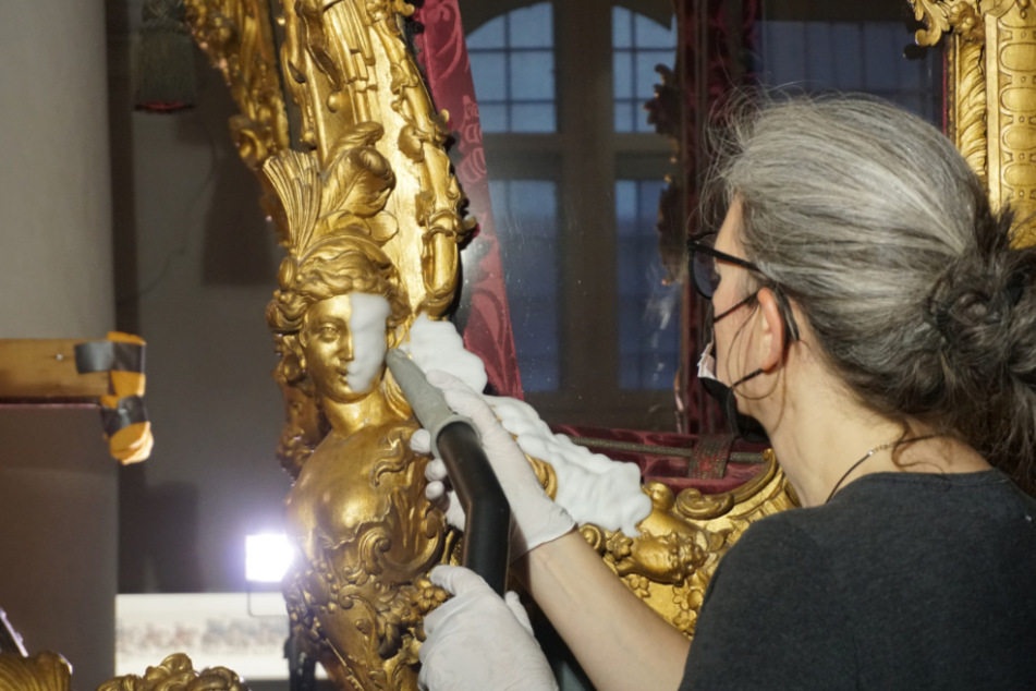 Eine Restauratorin reinigt die Krönungskutsche des bayerischen Kurfürsten Karl Albrecht und späteren Kaisers Karl VII. mit einem neu entwickelten Schaum.